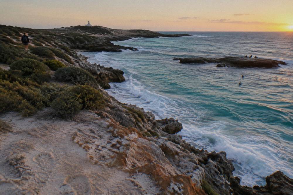 Rocky headland lookout above clear turquoise water at the island's western end
